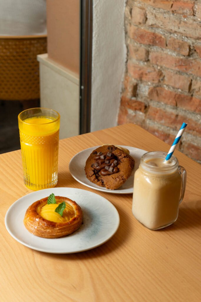 Desayuno en Ana La Fantástica: zumo de naranja, café con leche, cookie y danesa de melocotón