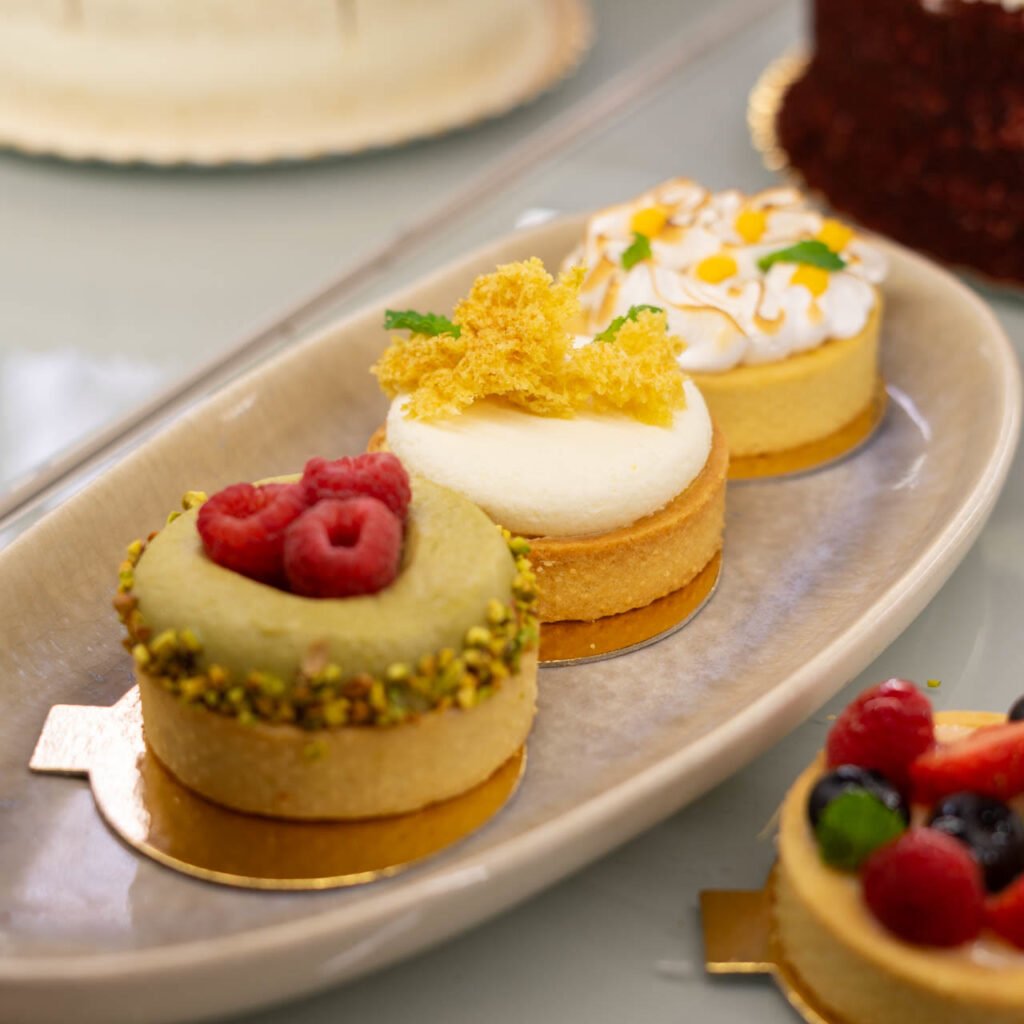 Tartaletas de pistacho, limón y frutos rojos en la vitrina